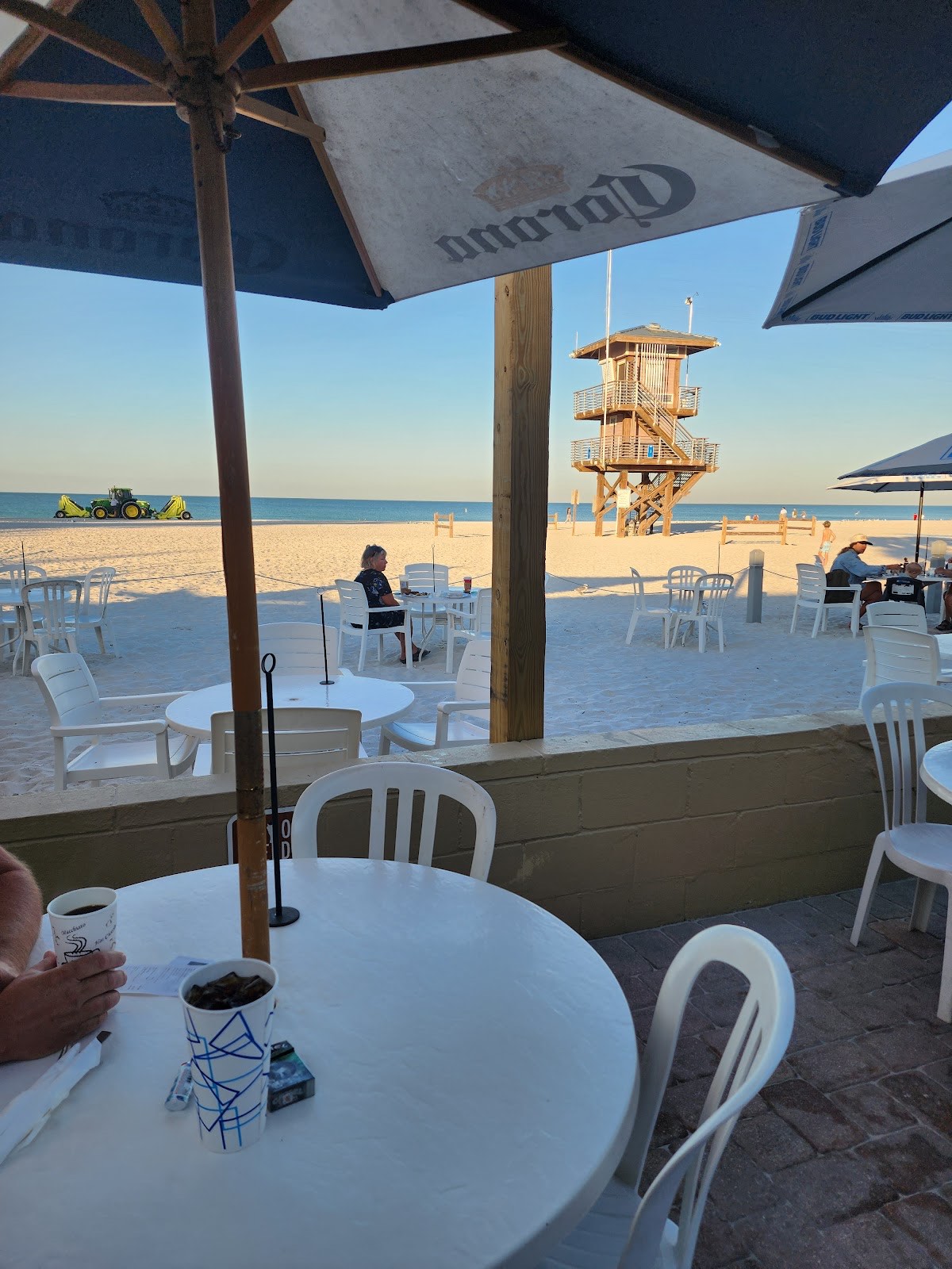 View from a shaded beach table out to the white sand, lifeguard tower and turquoise Gulf water